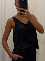 Musculosa negra con acabado satinado y sutil brillo, de corte holgado y diseño básico con breteles anchos.