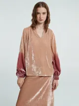 Blusa verde esmeralda de terciopelo con escote en V y mangas largas abullonadas con degradé a negro en los puños.