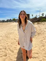 Camisola blanca con rayas verticales finas color marrón, de corte amplio y mangas largas.