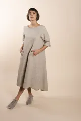 Vestido midi acampanado de lana fina sin teñir, con cuello bote, mangas tres cuartos con tajo y bolsillos laterales. Diseño forrado con vuelo y movimiento.