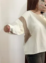 Buzo de punto con diseño geométrico en bloques de color blanco, amarillo pastel y marrón claro.