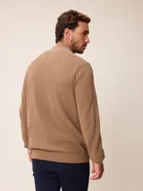 Cardigan de punto gris con cierre frontal completo, cuello tipo mao y puños acanalados. Presenta un pequeño logo bordado en el pecho y detalles en contraste en el interior del cuello y puños.