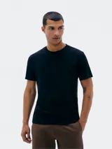 Remera básica de corte regular, con cuello redondo y mangas cortas, confeccionada en algodón liso.