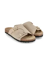 Sandalias planas color taupe, con diseño de dos tiras anchas ajustables mediante hebillas metálicas doradas. Cuenta con suela de corcho y base de goma negra con relieve.