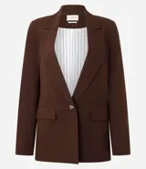 Blazer de sastrería color bordó, con cuello inglés, solapas clásicas y cierre frontal de un solo botón. Confeccionado en una mezcla de viscosa y lino, presenta un corte fluido y elegante.