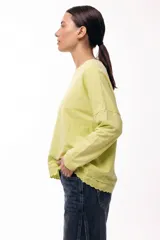 Remera de algodón color verde lima, de corte holgado y manga larga, con detalle de puntilla bordada en el ruedo.