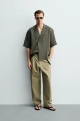 Camisa tipo kimono de corte relaxed fit, color celeste, confeccionada en tejido fluido de viscosa y lino. Presenta cuello con solapas de muesca, manga corta y cierre frontal cruzado con doble botonadura.