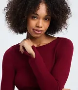 Suéter de punto ajustado con escote canoa y mangas largas. Presenta una superficie lisa y acabado clean, confeccionado en una mezcla de viscosa, poliéster y poliamida.