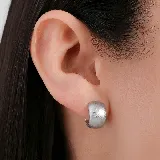 Aros tipo argolla pequeña de diseño ancho y superficie texturizada con acabado mate en tono dorado.