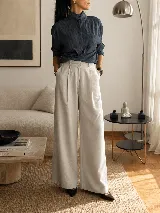 Pantalón de tiro alto con corte wide leg y diseño de pinzas frontales. Confeccionado en lino natural, presenta una silueta amplia y fluida con bolsillos laterales.