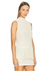 Musculosa color crema tejida a crochet, con cuello alto y flecos en el ruedo.