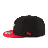 Gorra New Era modelo 9FIFTY de visera plana, color negro con visera y botón superior rojos. Presenta el logotipo bordado de los Chicago Bulls en el frente.