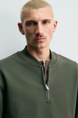 Sudadera de corte regular fit confeccionada en tejido de algodón con interior de rizo. Presenta cuello tipo rib, cierre frontal de cremallera y acabados en rib en puños y bajo.