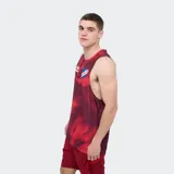 Musculosa deportiva Umbro del Club Nacional de Football, en tonos rojo y burdeos con estampado abstracto. Incluye el logo de Umbro en el pecho derecho y el escudo del club en el izquierdo.