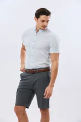 Bermuda cargo de gabardina en color gris oscuro, corte recto, con bolsillos laterales con solapa y cierre de botones y cremallera.