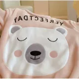 Conjunto de pijama de dos piezas confeccionado en tela de plush suave y abrigada. Incluye una remera de manga larga con diseño estampado de Totoro y pantalón largo a juego con puños en contraste.