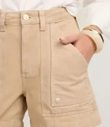 Short mom de tiro alto confeccionado en sarga de algodón, con diseño de bolsillos tipo carpintero en la parte frontal, cierre de botón y cremallera, y trabillas en la cintura.