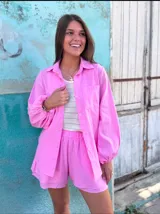 Conjunto de dos piezas confeccionado en lino color blanco. Incluye una camisa de corte holgado con mangas abullonadas y bolsillos frontales, y un short de tiro alto con cintura elástica y forro interior.