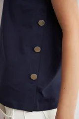 Remera azul marino de manga corta, con corte holgado y detalle de botones metálicos en los laterales.