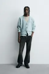 Cárdigan de punto con mezcla de algodón, de corte relajado y cuello en pico. Presenta un diseño con efecto de roturas y acabado jaspeado en tonos azul y blanco, con cierre frontal de botones y puños y bajo en rib.