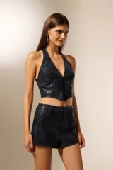 Top tipo corset de eco-cuero con textura de reptil, escote profundo en V y cierre frontal. Diseño al cuerpo sin mangas.