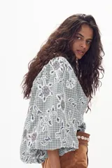 Camisa celeste a cuadros con apliques florales bordados con canutillos, mangas largas abullonadas con puños fruncidos, cuello camisero clásico y botones de nácar.