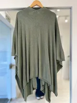 Ruana verde con acabado brillante metalizado, diseño abierto y corte amplio.