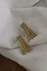 Par de aros de bronce con forma abstracta de líneas onduladas.