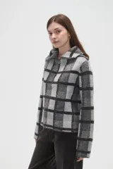 Sweater de tejido jacquard con diseño de cuadros, cuello solapa y cierre frontal parcial. Presenta un corte holgado y mangas largas.