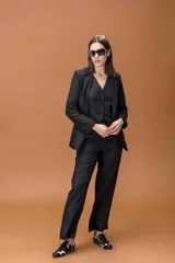 Blazer negro de corte clásico y estructurado, con solapas tradicionales y cierre frontal, diseñado para ofrecer un acabado sofisticado y versátil.