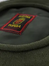 Boina de hilo tejida en color beige, con forro interior oscuro y etiqueta de la marca Tolosa.