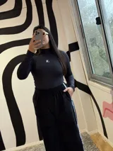 Pantalón de jogging negro de plush, con elástico en la cintura, bolsillos laterales y cinta con logo a lo largo de la pierna.