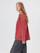 Remera de manga larga con cuello redondo, confeccionada en algodón con efecto lavado. Presenta costuras decorativas en color contrastante en sisas, mangas y frente, con un corte holgado y logo bordado en el frente.