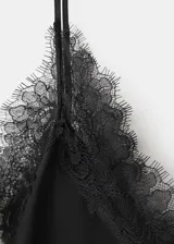 Top de tejido satinado negro, con cuello en V, ribetes de encaje, tirantes finos y diseño sin mangas.