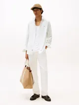 Camisa de manga larga con diseño de rayas finas, confeccionada en mezcla de algodón regenerativo y elastano. Presenta un corte slim fit, cuello clásico, cierre con botones, puños abotonados y logo de Tommy Hilfiger bordado en el pecho.