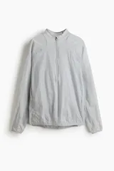 Campera deportiva liviana color gris, resistente al agua, con cuello elevado y cierre frontal. Cuenta con tecnología DryMove para absorber el sudor, mangas largas con puños elásticos y diseño plegable.