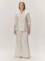 Pantalón de lino color tostado, de corte amplio y fluido con piernas acampanadas.