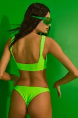 Conjunto de bikini verde neón confeccionado en lycra mate premium. El corpiño es un top con recortes y escote cuadrado, con breteles anchos. La bombacha es vedetina.