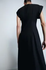Vestido midi de Zara Woman Collection confeccionado en popelín de algodón. Presenta cuello redondo, manga corta y detalle de pliegues en la cintura que dan paso a una falda con caída evasé. Cierre posterior con abertura y botón.