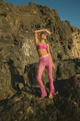 Pantalón de playa confeccionado en tul semitransparente con estampado de ondas en tonos violeta y verde lima. Presenta un corte recto y holgado con cintura elástica.