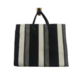 Cartera tipo tote de diseño rectangular con estampado de rayas verticales en tonos negro, gris y blanco. Presenta doble asa superior en color negro.