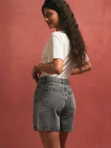 Short de denim gris claro, tiro alto, con bolsillos delanteros y traseros.