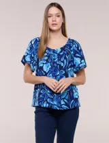 Blusa de poliéster azul con estampado botánico y floral, de silueta holgada y fluido diseño. Cuenta con escote redondo elastizado con frunces y mangas cortas amplias.