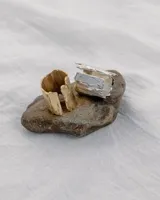 Anillo abierto de diseño rústico y orgánico, con textura irregular que evoca la naturaleza. Realizado artesanalmente en metal.