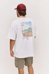Remera oversize blanca de manga corta, con corte amplio y estampa gráfica pequeña en el pecho.