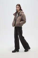 Campera puffer negra con capucha, manga larga, cierre frontal y cuello alto.