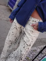 Jean de tiro medio y silueta recta levemente acampanada, con estampado tipo cowhide print. Cuenta con cierre frontal, botón y bolsillos funcionales.