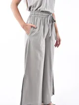 Pantalón de corte ancho y tiro alto, con cintura elástica y lazo ajustable del mismo tejido.