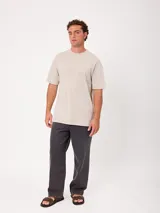 Remera holgada de algodón color beige con lavado ácido, cuello redondo ancho y diseño de tres pequeños círculos estampados en el pecho.