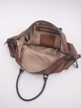 Bolso de viaje tipo duffle, confeccionado en cuero natural color azul con textura, con detalles de correas y asas en cuero color suela. Cuenta con cierre superior, bolsillo interior con cierre y compartimento para celular.